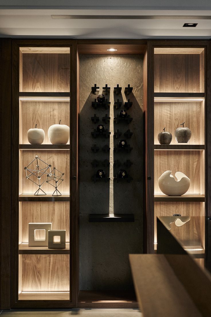 Tall glass display cabinet with golden accents and built-in LED lighting