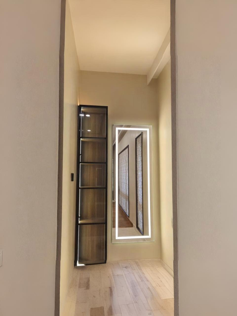 Modern kitchen wall cabinets with black aluminium frames, glass doors, and integrated LED lighting
