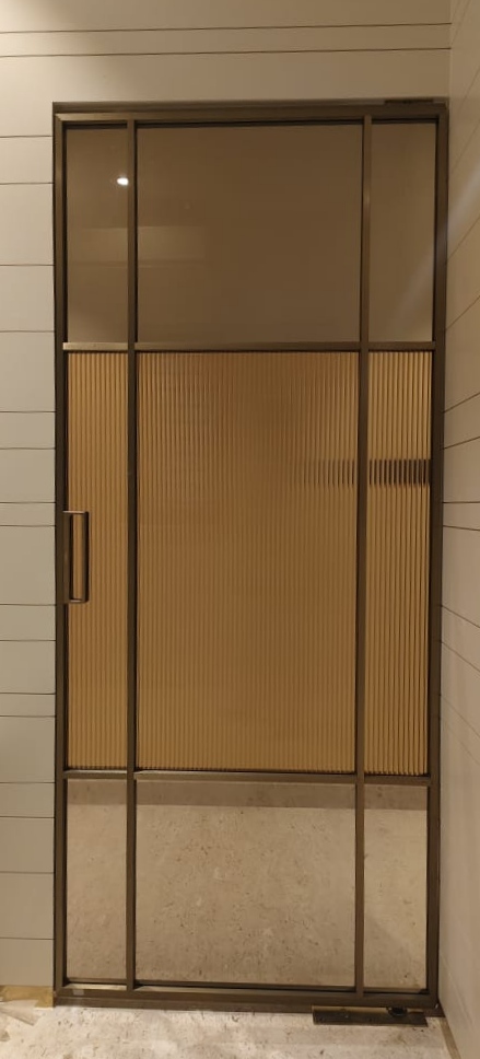 Modern bronze-framed glass door with ribbed glass panel for contemporary interiors